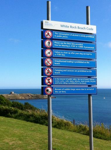 This large blue Beach Bye Law sign obscurs the view of Dalkey Island from the entrance to Whie Rock along Vico Road